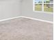 An open carpeted room is filled with natural light from a window at 715 Colvin Dr, Locust Grove, GA 30248