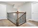 Carpeted staircase with stained wooden handrail and decorative iron spindles at 715 Colvin Dr, Locust Grove, GA 30248