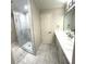 Bright bathroom featuring a glass shower, patterned tile, and a long vanity with modern fixtures at 255 Carriage Station Dr, Lawrenceville, GA 30046