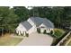Stunning two-story brick home featuring a well-manicured lawn, a circular driveway, and lush, mature landscaping at 255 Carriage Station Dr, Lawrenceville, GA 30046