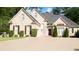 Charming brick home showcasing manicured bushes, dark shutters, a well-maintained lawn, and a spacious driveway at 255 Carriage Station Dr, Lawrenceville, GA 30046