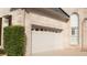 Exterior view of an attached garage with neutral brick, white garage door, and manicured landscaping at 255 Carriage Station Dr, Lawrenceville, GA 30046