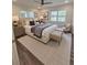 A relaxing main bedroom features an upholstered bed, wood floors, two windows, and designer lamps at 255 Carriage Station Dr, Lawrenceville, GA 30046