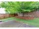 Landscaped backyard featuring a small grass yard with a retaining wall and tree at 118 Brendylynn Trce, Woodstock, GA 30188