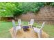 Backyard fire pit and chairs on pea gravel, with retaining wall and tree at 118 Brendylynn Trce, Woodstock, GA 30188