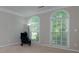 Bedroom with neutral walls, two arched windows with blinds, and a black reading chair at 118 Brendylynn Trce, Woodstock, GA 30188