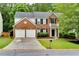 Charming two-story brick home featuring an attached two-car garage and manicured front lawn at 118 Brendylynn Trce, Woodstock, GA 30188