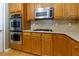 Close-up of kitchen featuring stainless steel appliances, a gas cooktop, and light wooden cabinetry at 118 Brendylynn Trce, Woodstock, GA 30188