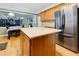 Kitchen island next to a stainless steel fridge with hardwood floors and seamless connection to the dining and living areas at 118 Brendylynn Trce, Woodstock, GA 30188