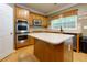 A well-lit kitchen with stainless steel appliances, wooden cabinets, and a central island providing ample counter space at 118 Brendylynn Trce, Woodstock, GA 30188