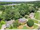 Aerial view showcases a brick home nestled among green trees with a well-manicured lawn and community at 208 Regency Ct, Acworth, GA 30102