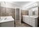 Bathroom with double vanity, tile floor and walls, and walk-in closet access at 208 Regency Ct, Acworth, GA 30102