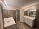 Bathroom featuring double sinks, decorative tile walls, and walk-in closet access at 208 Regency Ct, Acworth, GA 30102