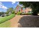A stately brick home has a manicured lawn with lush plantings leading up to the front entryway at 208 Regency Ct, Acworth, GA 30102