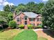 Charming two-story brick home with manicured lawn and lush landscaping at 208 Regency Ct, Acworth, GA 30102