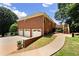 Exterior view of a brick home with a three-car garage, deck, and lush landscaping at 208 Regency Ct, Acworth, GA 30102