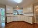 White cabinets, tile backsplash, and hardwood flooring enhance this delightful kitchen at 208 Regency Ct, Acworth, GA 30102