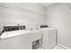 Well-lit laundry room with a utility sink, washer, and dryer at 208 Regency Ct, Acworth, GA 30102