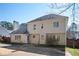 Back exterior featuring a two-story home with a large backyard, complemented by mature trees and a fence at 3090 Perch Sw Ln, Marietta, GA 30008