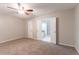 Carpeted main bedroom with ceiling fan, closet, and doorway to en-suite bathroom at 5888 Old Wellborn Trce, Lithonia, GA 30058