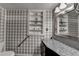 Traditional bathroom with a granite vanity top, built in shelving, and plaid wallpaper accents at 617 Rock Springs Rd, Lawrenceville, GA 30043