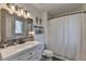 Bathroom with a vanity, updated mirror, decorative lights, and a shower with a patterned curtain at 617 Rock Springs Rd, Lawrenceville, GA 30043