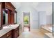 Bathroom with wooden vanity, marble counters, and entrance to closet with arched window at 760 River Gate Dr, Atlanta, GA 30350