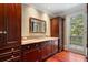 Bathroom featuring custom cabinets, granite countertops, and access to outdoor patio at 760 River Gate Dr, Atlanta, GA 30350