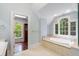 Bright bathroom with a soaking tub under windows, a marble top vanity, and access to a closet at 760 River Gate Dr, Atlanta, GA 30350