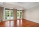 Sunlit bedroom with hardwood floors, french doors, and elegant curtains overlooking the pool at 760 River Gate Dr, Atlanta, GA 30350
