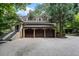 Stone and brick exterior with a three-car garage and mature trees at 760 River Gate Dr, Atlanta, GA 30350