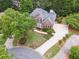 Aerial view of brick home with manicured lawn, mature trees, and circular driveway at 151 Overhill Point, Alpharetta, GA 30005