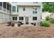 Backyard view of the home exterior featuring a stone patio with an outdoor seating area and fire pit at 151 Overhill Point, Alpharetta, GA 30005