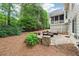 Landscaped backyard featuring a patio area with outdoor seating and lush greenery at 151 Overhill Point, Alpharetta, GA 30005
