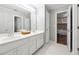 Well-lit bathroom with a double sink vanity and view into an adjacent room at 151 Overhill Point, Alpharetta, GA 30005