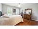 Cozy bedroom with hardwood floors, neutral walls, shutters, and a vintage-style dresser at 151 Overhill Point, Alpharetta, GA 30005
