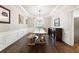 Elegant dining room features a large rustic table, wainscoting, and a gorgeous chandelier at 151 Overhill Point, Alpharetta, GA 30005
