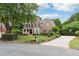 Charming brick home features a manicured lawn, mature trees and a long driveway at 151 Overhill Point, Alpharetta, GA 30005