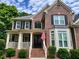 Inviting brick facade with a covered porch, black shutters, and a charming entryway at 151 Overhill Point, Alpharetta, GA 30005