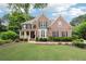 Traditional two-story brick home with manicured lawn and charming front porch at 151 Overhill Point, Alpharetta, GA 30005