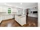 Open concept kitchen with granite countertops, white cabinetry and a large island with cooktop at 151 Overhill Point, Alpharetta, GA 30005