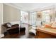 Inviting living room with gleaming wood floors, plantation shutters and a plush sofa and leather chair at 151 Overhill Point, Alpharetta, GA 30005