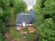 Aerial view of a charming home with a deck and fire pit surrounded by lush greenery at 262 Devynwood Ln, Dallas, GA 30157