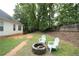 Cozy backyard seating area with chairs around a stone fire pit, perfect for outdoor relaxation at 262 Devynwood Ln, Dallas, GA 30157