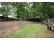 Spacious backyard features a wooden fence, mature trees, and potential for outdoor activities and landscaping at 262 Devynwood Ln, Dallas, GA 30157