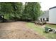 Large backyard with a wooden deck, mature trees, and ample space for recreation or gardening at 262 Devynwood Ln, Dallas, GA 30157