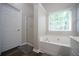 Bathroom featuring a soaking tub with tile surround and a window at 262 Devynwood Ln, Dallas, GA 30157