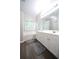 Bright bathroom featuring a double vanity, soaking tub, and wood-look flooring at 262 Devynwood Ln, Dallas, GA 30157