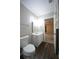 Bright bathroom featuring a white vanity, toilet, and wood-look flooring at 262 Devynwood Ln, Dallas, GA 30157