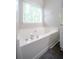 Bright, spacious bathtub with tile surround and a window at 262 Devynwood Ln, Dallas, GA 30157